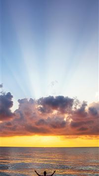 man raising his arms on sea under black clouds wallpaper
