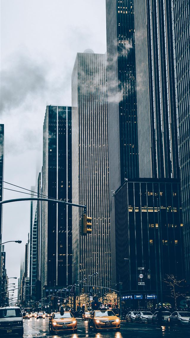 1284x2778 two yellow cars besides concrete buildings - trees iPhone Wallpaper