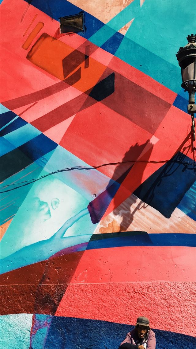 1284x2778 man sitting on wall with artwork and lamp - morocco iPhone Wallpaper