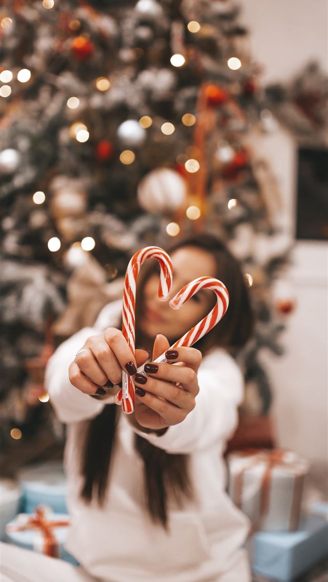 1284x2778 woman holding candy canes - winter iPhone Wallpaper