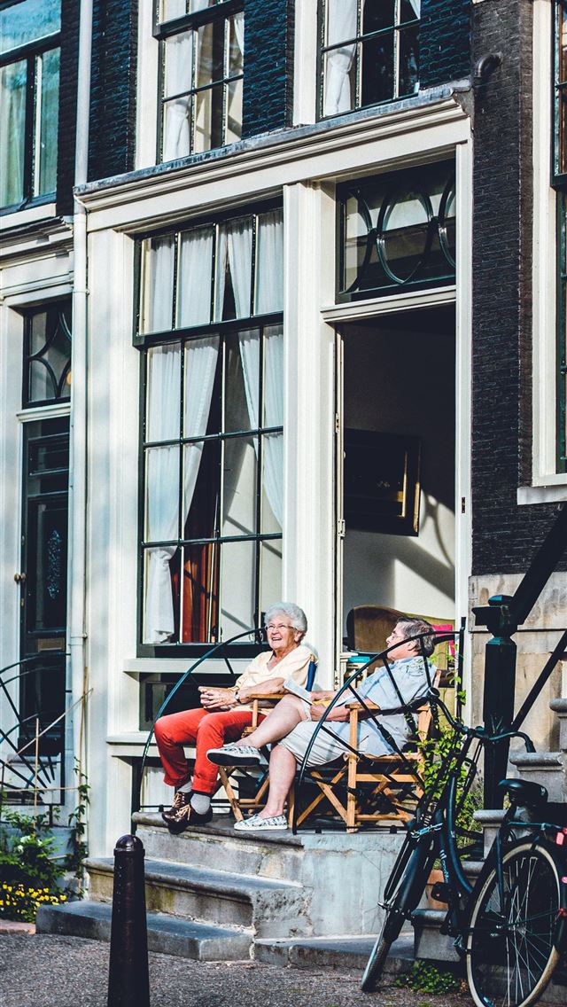 1284x2778 two person sitting in front of door - netherlands iPhone Wallpaper