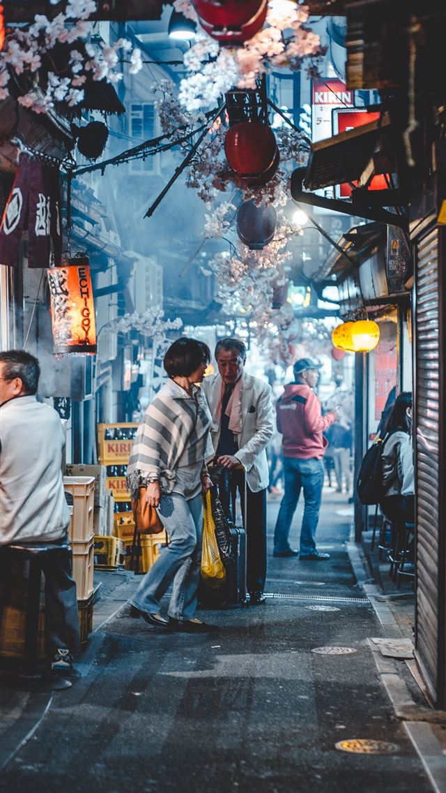 1284x2778 man sitting in front of store - japan iPhone Wallpaper