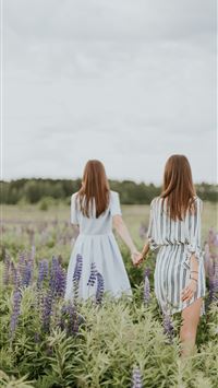 two women surrounded by lavender under nimbus clou... wallpaper