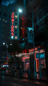 empty road between buildings at night time wallpaper
