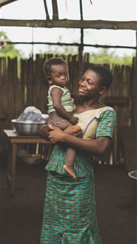 smiling woman standing while holding baby wallpaper