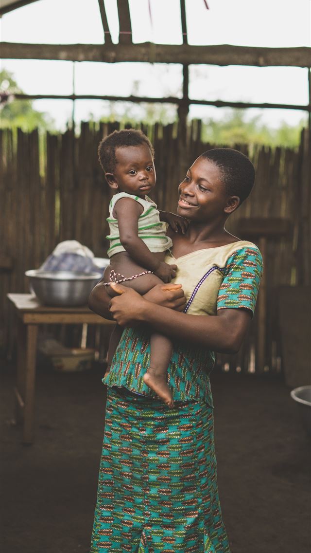 1284x2778 smiling woman standing while holding baby - togo iPhone Wallpaper