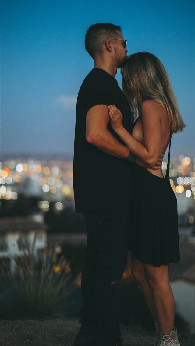 1284x2778 man hugging woman on top of hill during nighttime - los angeles iPhone Wallpaper