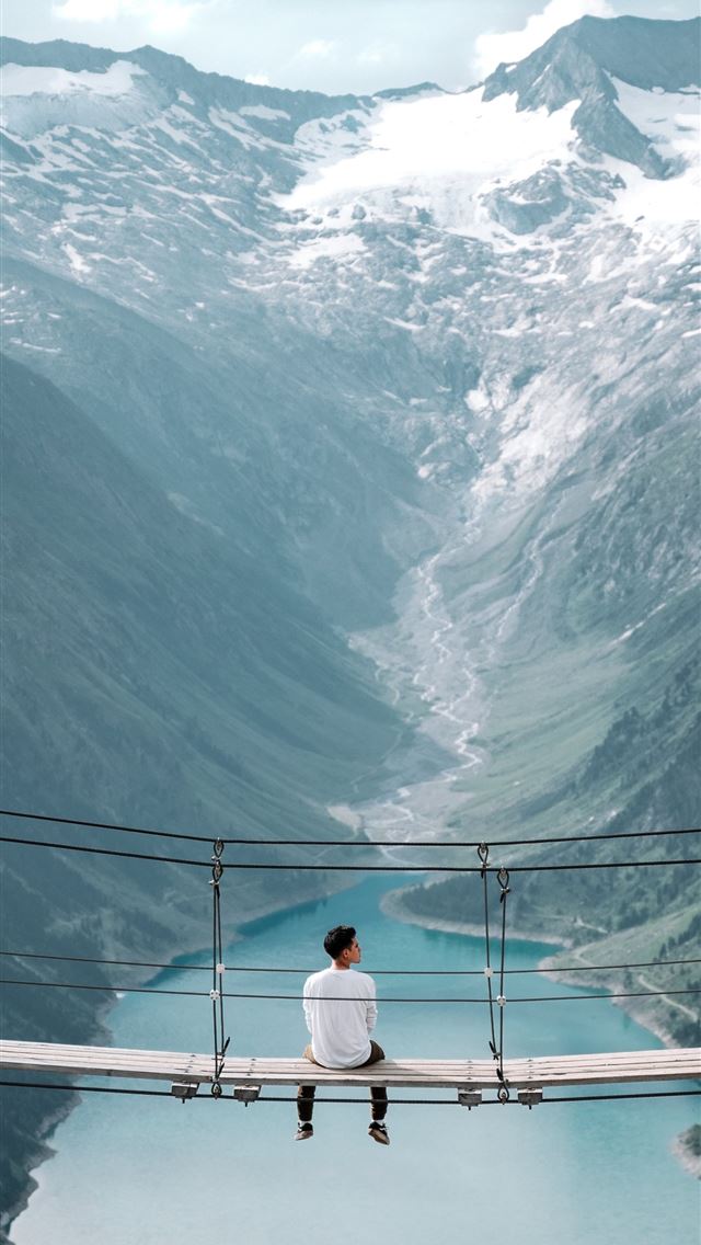 1284x2778 man wearing white shirt siting on bridge overlooki... - austria iPhone Wallpaper
