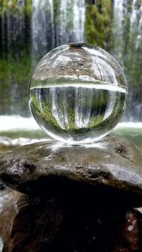 clear glass ball on brown rock wallpaper