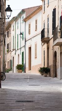 straight alley road with brown buildings wallpaper