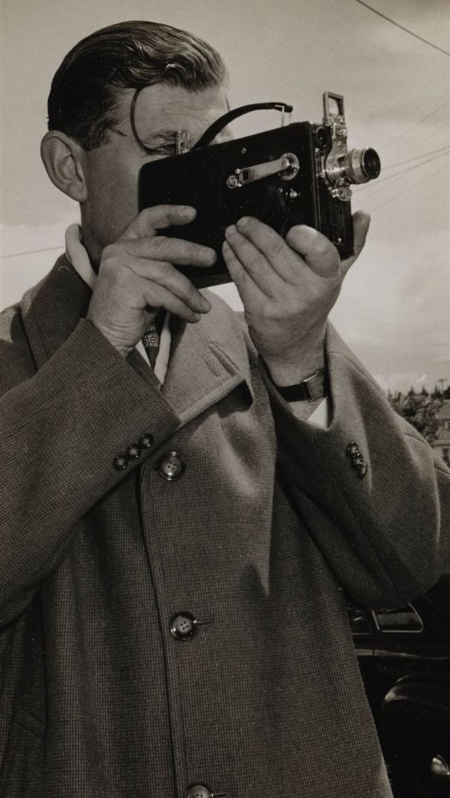 1284x2778 man holding black camera -  iphone 13 Wallpaper