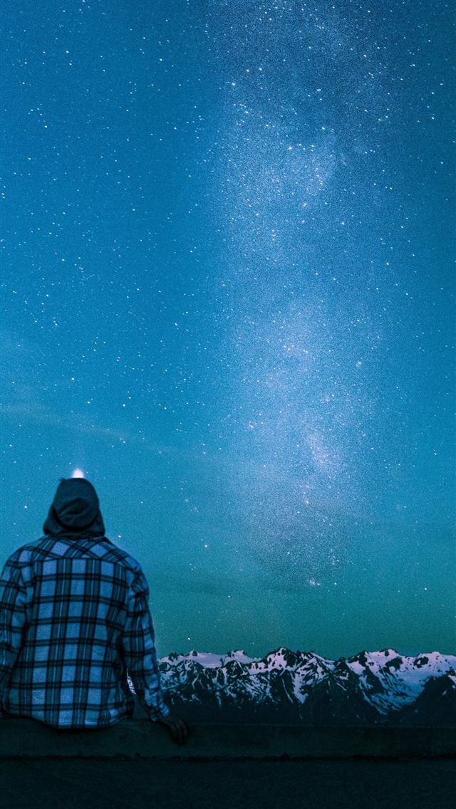 1284x2778 man sitting on gray wall looking at the stars - united states iPhone Wallpaper