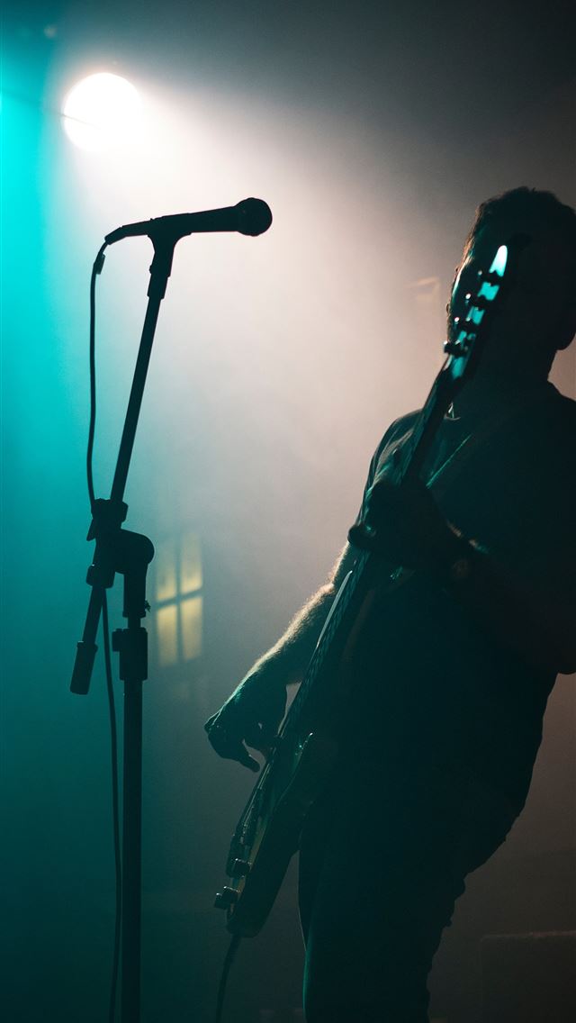 1284x2778 man holding electric guitar - music iPhone Wallpaper