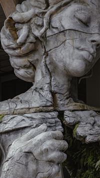 gray concrete statue of man holding stick wallpaper