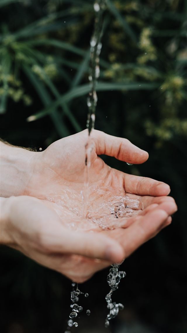1290x2796 water drop on persons hand -  iphone 14 Wallpaper