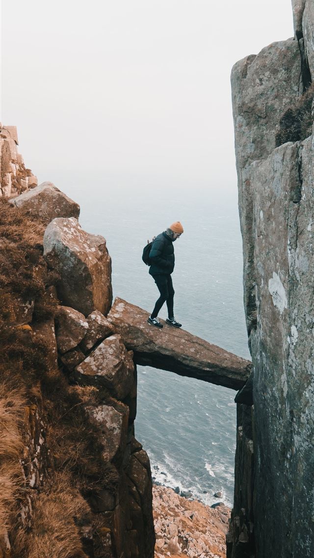 1290x2796 man standing on rock in the middle of clip - spring iPhone Wallpaper