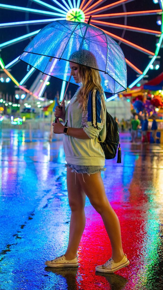 1290x2796 woman walking on pavement holding umbrella - night iPhone Wallpaper
