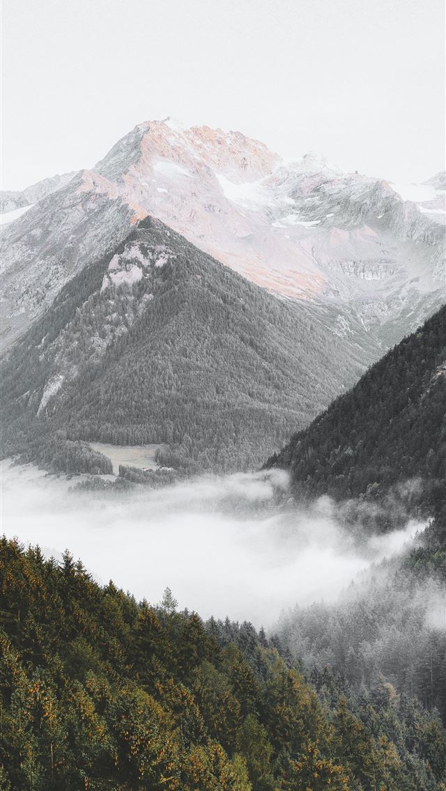 1290x2796 a mountain range covered in fog and low lying clou... - mountain iPhone Wallpaper