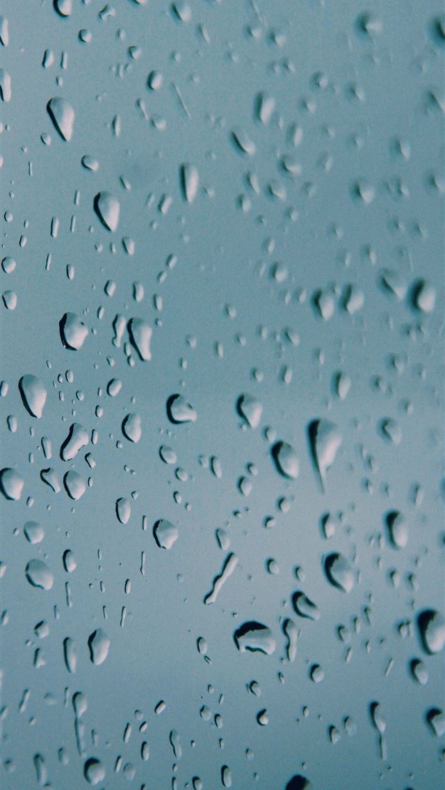 1290x2796 a close up of water droplets on a blue surface -  iphone 14 Wallpaper