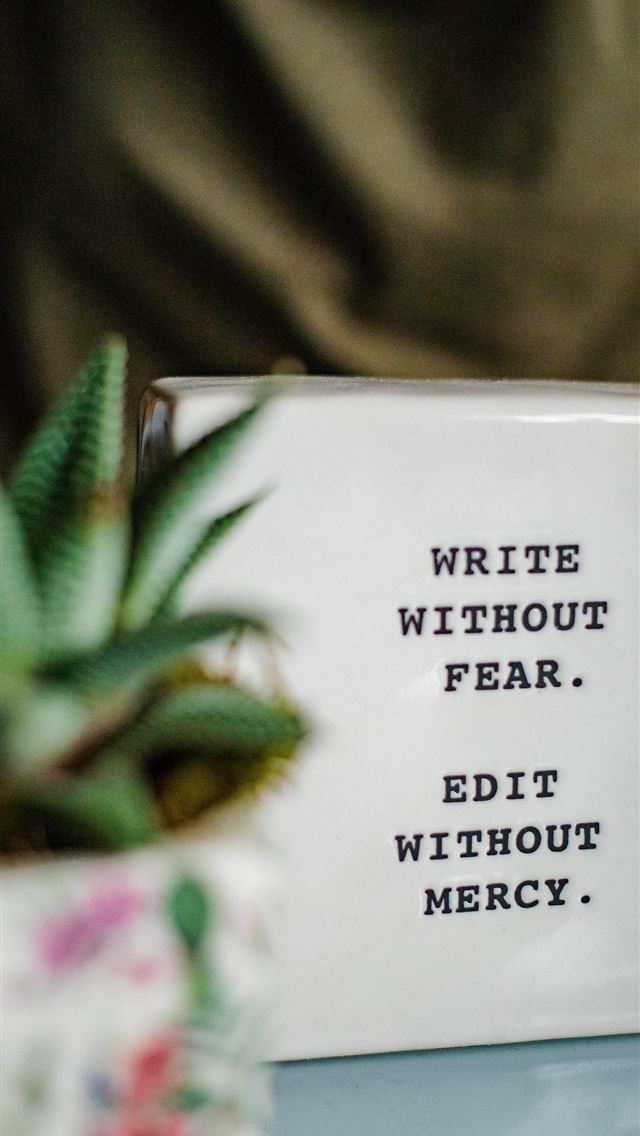 1290x2796 a white box with writing on it next to a plant - life iPhone Wallpaper