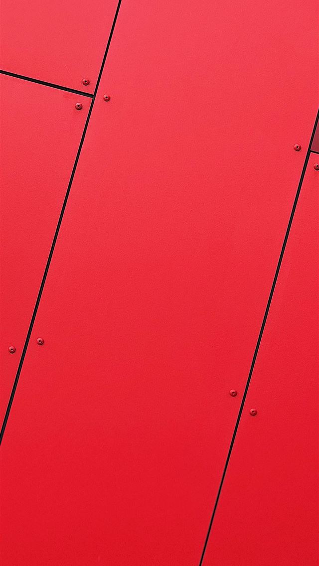 1290x2796 a close up of a red wall with metal rivets - texture iPhone Wallpaper