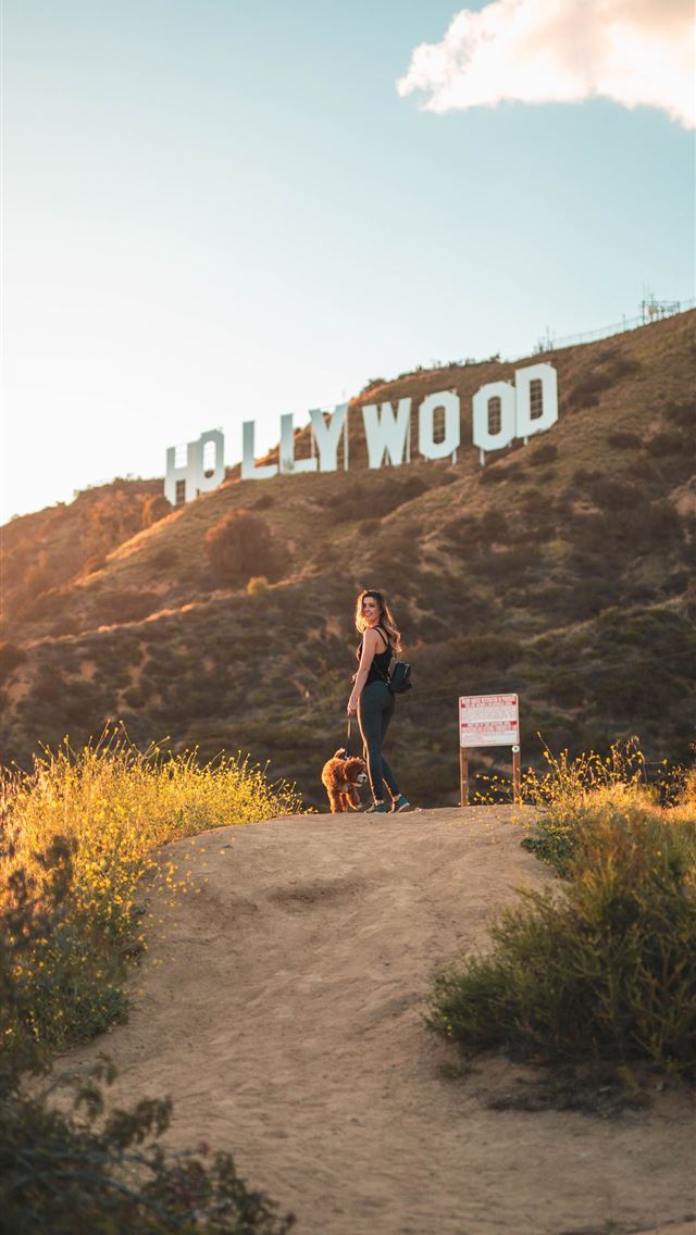 1290x2796 woman standing with brown dog - trees iPhone Wallpaper