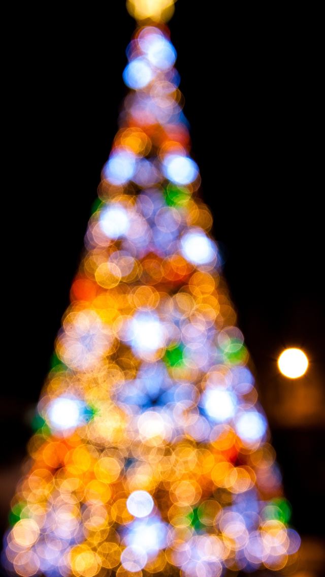 1290x2796 a brightly lit christmas tree in the dark - lights iPhone Wallpaper