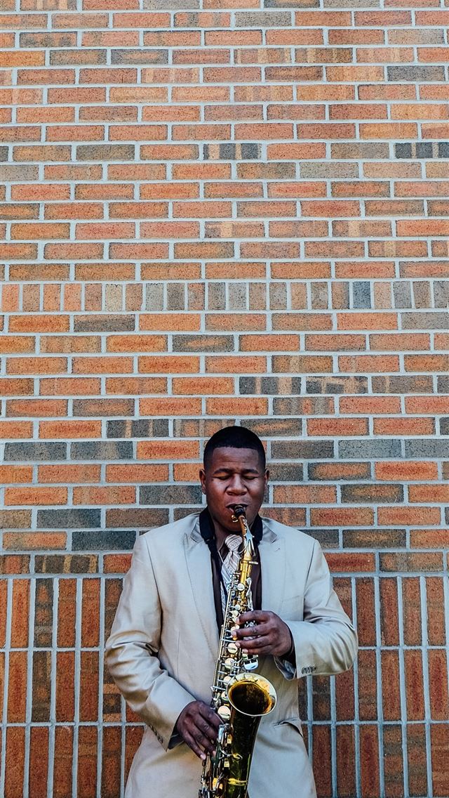 1290x2796 man playing saxophone near concrete brick - quotes iPhone Wallpaper