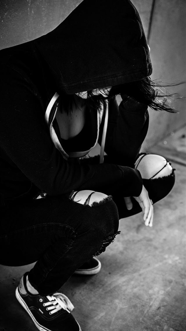 1290x2796 a woman sits alone against a wall holding her head - quotes iPhone Wallpaper