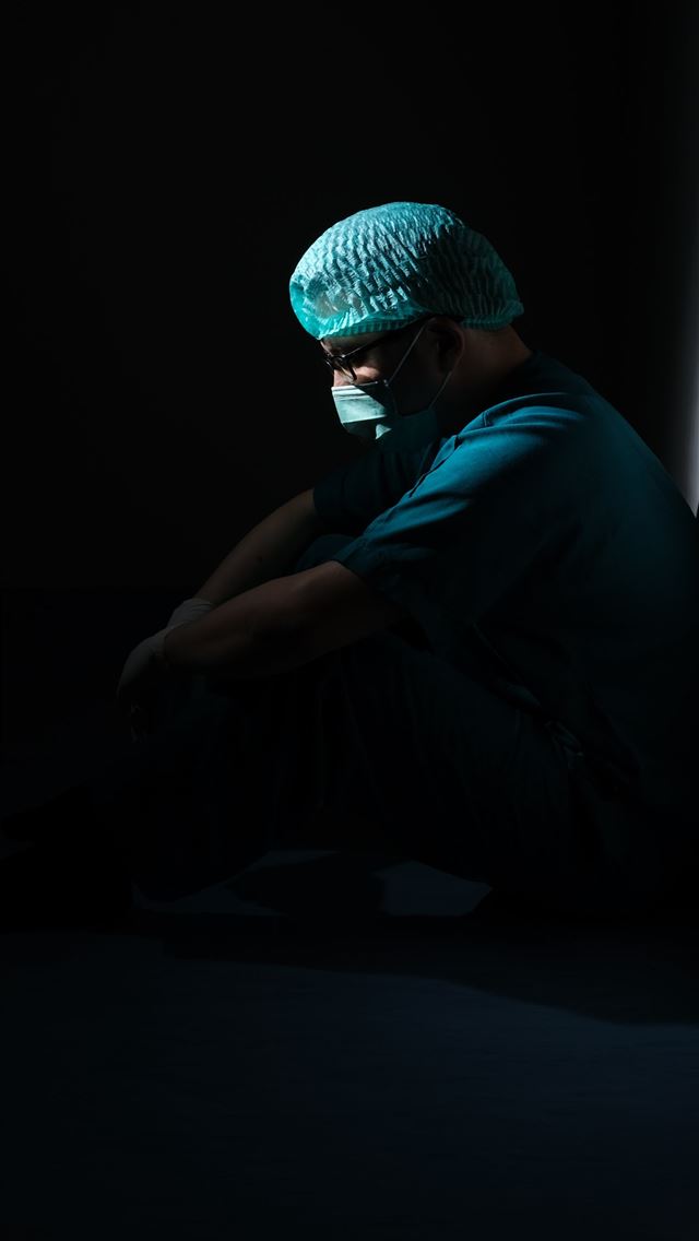 1290x2796 man in green shirt and blue knit cap sitting on fl... -  iPhone Wallpaper