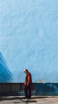man standing near blue wall wallpaper