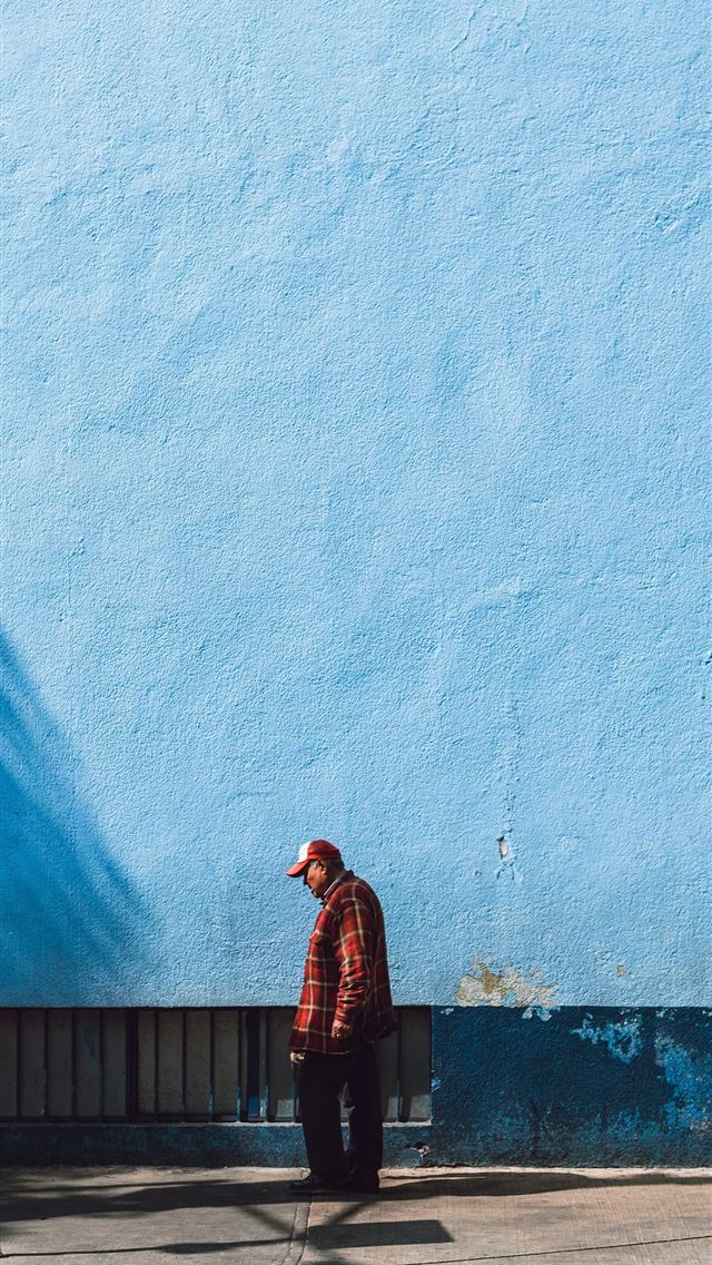 1290x2796 man standing near blue wall - mexico iPhone Wallpaper