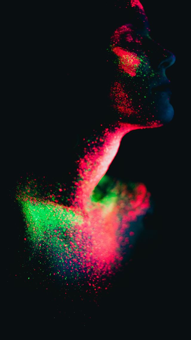 1290x2796 a woman's face is lit up with colored powder - neon iPhone Wallpaper