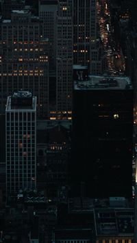 a view of a city at night from the top of a buildi... wallpaper