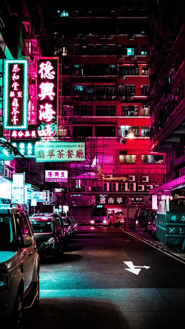 1290x2796 vehicles park on roadway between lighted buildings... - car iPhone Wallpaper