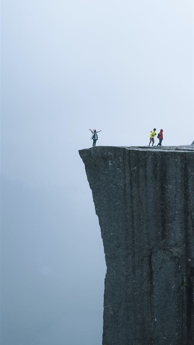 1290x2796 three persons standing near the edge of a cliff du... -  iPhone Wallpaper