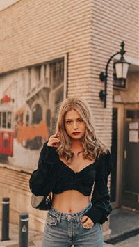 woman in black cardigan and white crop top standin... wallpaper