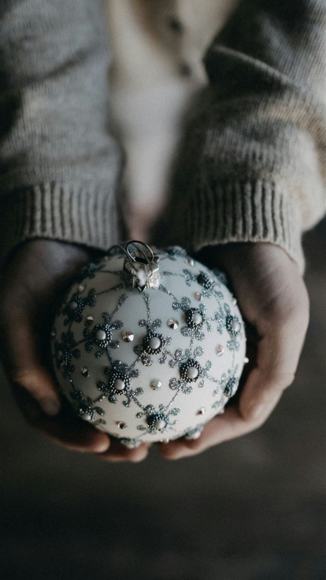 1290x2796 person holding bauble ball - silver iPhone Wallpaper