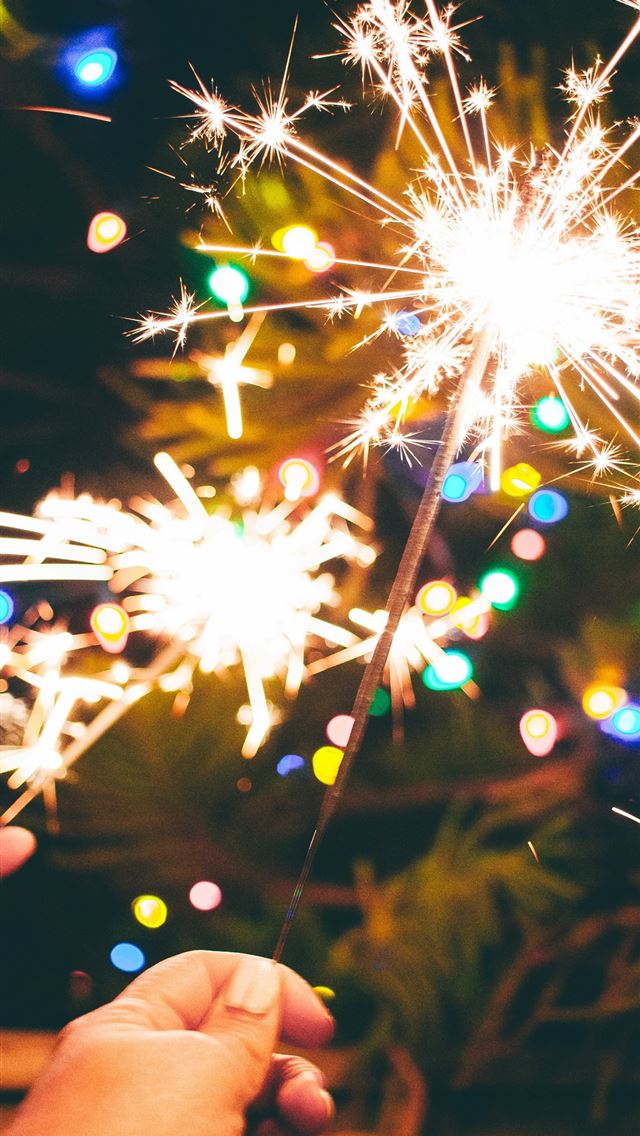1290x2796 a person is holding a sparkler in their hand - sparkles iPhone Wallpaper