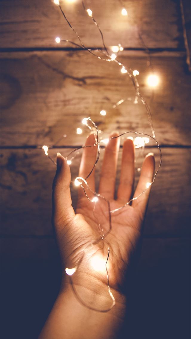 1290x2796 person holding white string light - grey iPhone Wallpaper