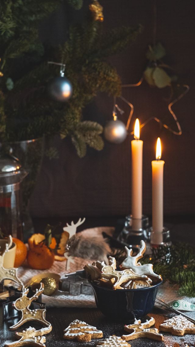 1290x2796 two lighted taper candles beside Christmas tree - deer iPhone Wallpaper