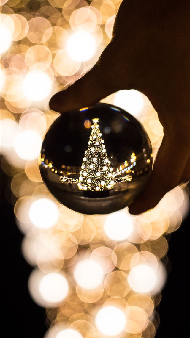 1290x2796 person holding glass bauble - yellow iPhone Wallpaper