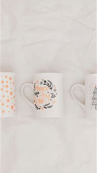 three white and multicolored ceramic mugs on white... wallpaper