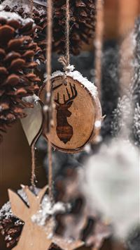 brown wooden heart ornament on brown pine cone wallpaper