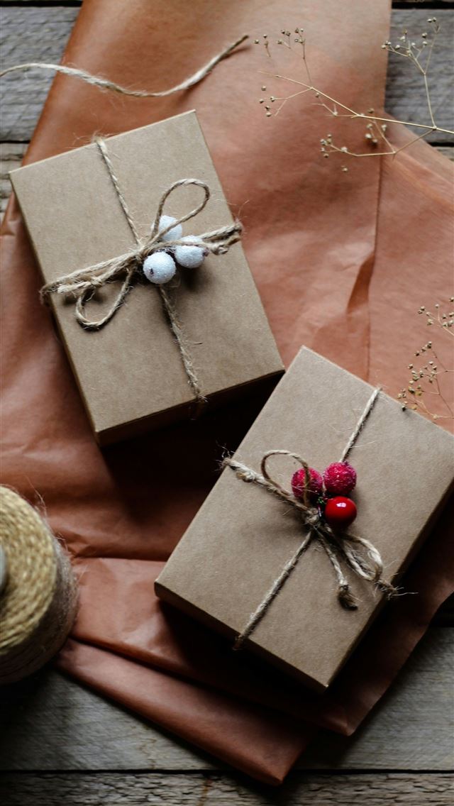 1290x2796 two wrapped presents sitting on top of a wooden ta... - christmas iPhone Wallpaper