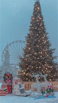 christmas tree with string lights and baubles near... wallpaper