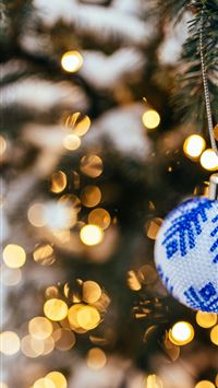 blue and white bauble hanging on christmas tree in... wallpaper