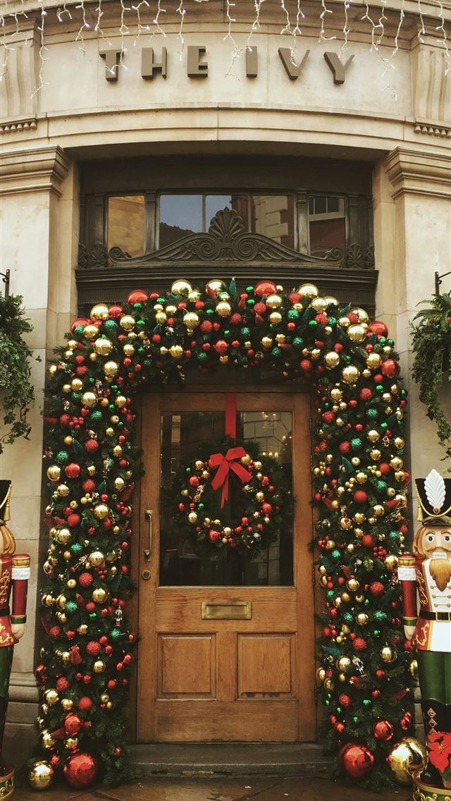 1290x2796 red green and yellow wreath on brown wooden door - christmas iPhone Wallpaper