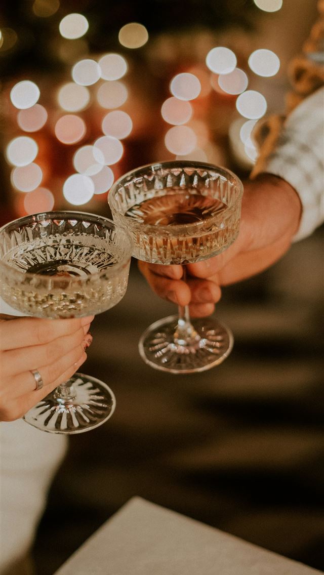 1290x2796 two people holding wine glasses in front of a chri... - lights iPhone Wallpaper