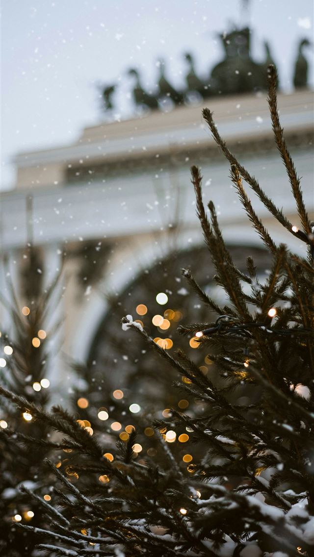 1290x2796 a close up of a christmas tree with a building in ... - christmas iPhone Wallpaper